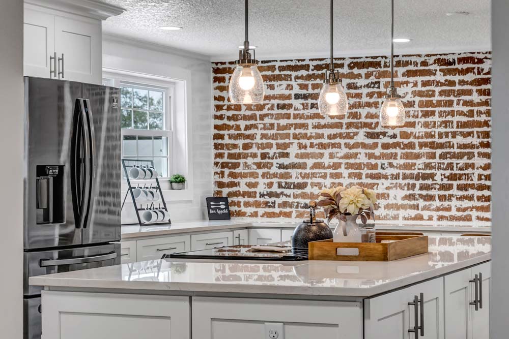 A kitchen with cabinetry, countertops, drawers, cupboards, a kitchen sink, tap, plumbing fixture, tile, home appliances, interior design, and a window is illuminated by the ceiling light.